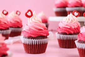Stock photo showing close-up view of a batch of freshly baked, homemade, red velvet cupcakes in pape...