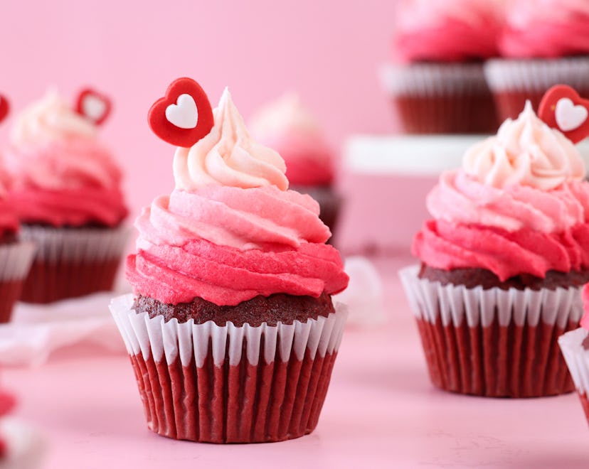 Stock photo showing close-up view of a batch of freshly baked, homemade, red velvet cupcakes in pape...