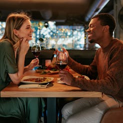 A happy young couple is on a Valentines day dinner date in a fancy restaurant.