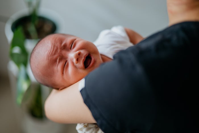 Image of an Asian Chinese mother comforts a crying baby