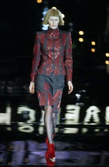 Givenchy Sonbahar/Kış 1999 hazır giyim defilesinde kırmızı devre motifli gri etek...