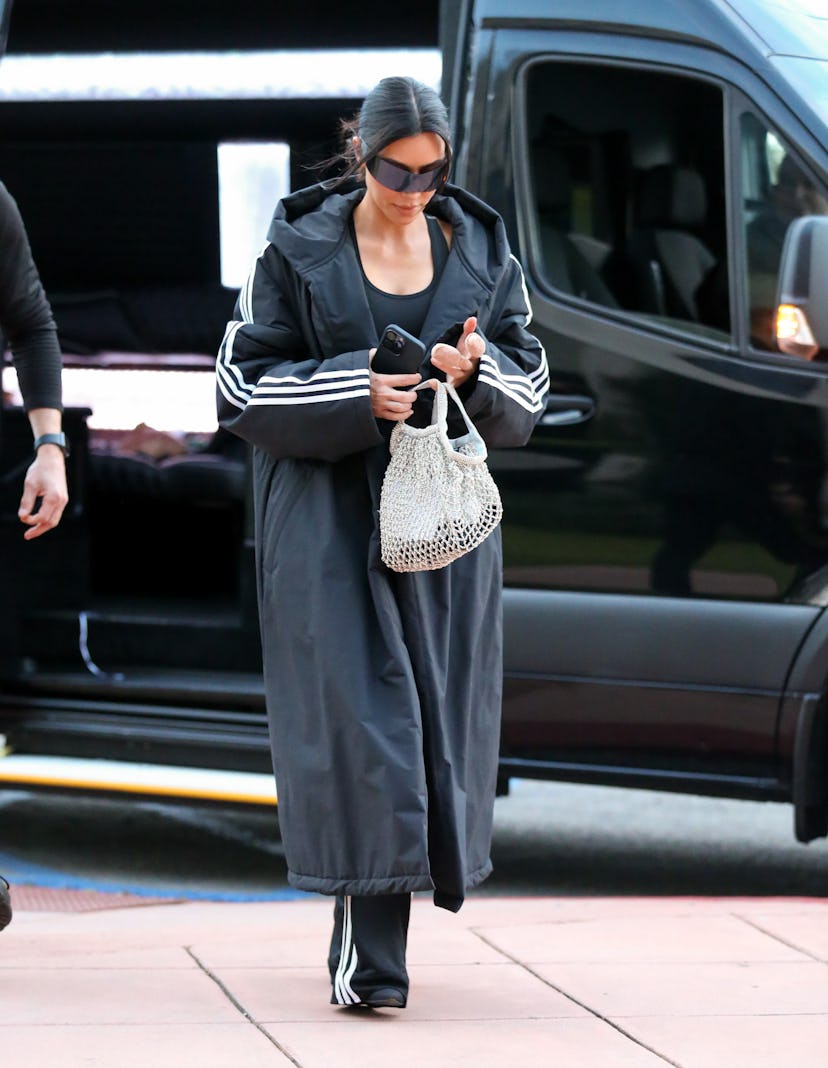 Kim Kardashian wears an all-black ensemble with a sparkly net bag on February 16, 2024 in Los Angele…
