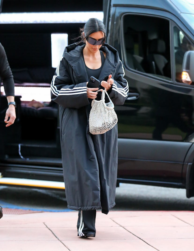 Kim Kardashian wears an all-black ensemble with a sparkly net bag on February 16, 2024 in Los Angele...