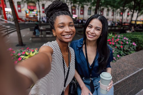 Office lunch break outdoors, two women in business taking a selfie after the ate their healthy salad...