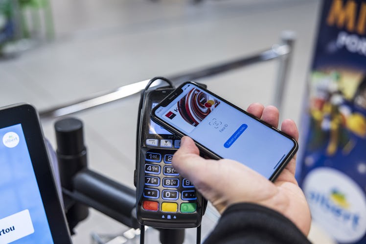 A customer uses Apple pay mobile payment at a contactless payment terminal inside an Albert hypermar...
