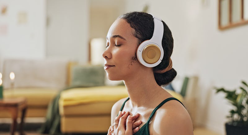 Woman, meditation and yoga in headphones listening to calm music, holistic exercise and peace in liv...