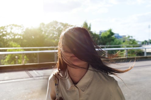 Fun portrait of a asian young woman hiding behind her long hair