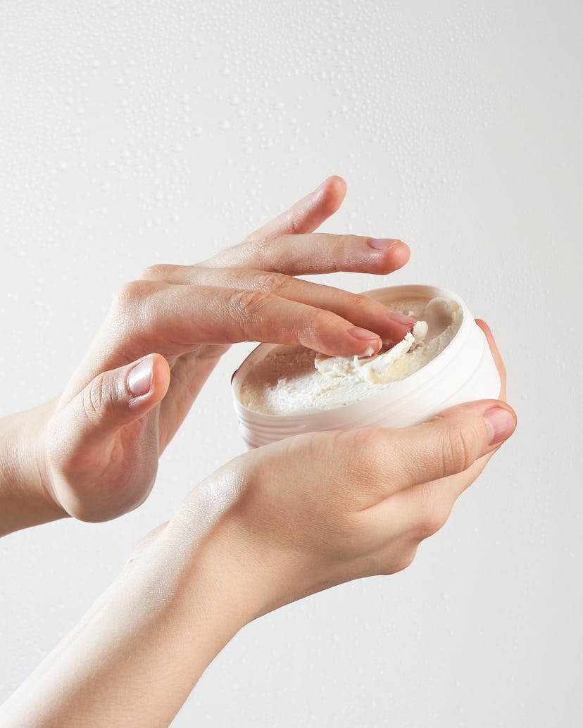 Woman applying hand cream or body butter