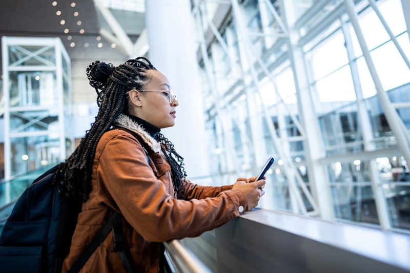 Young woman using phone at the airport