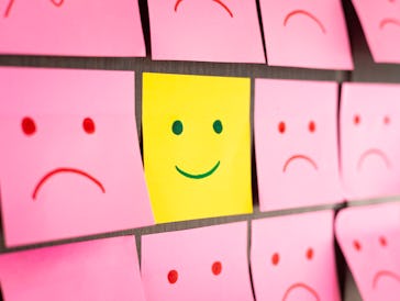 Sad faces on sticky notes and one happy face in center, Standing Out From The Crowd With Smiling fac...