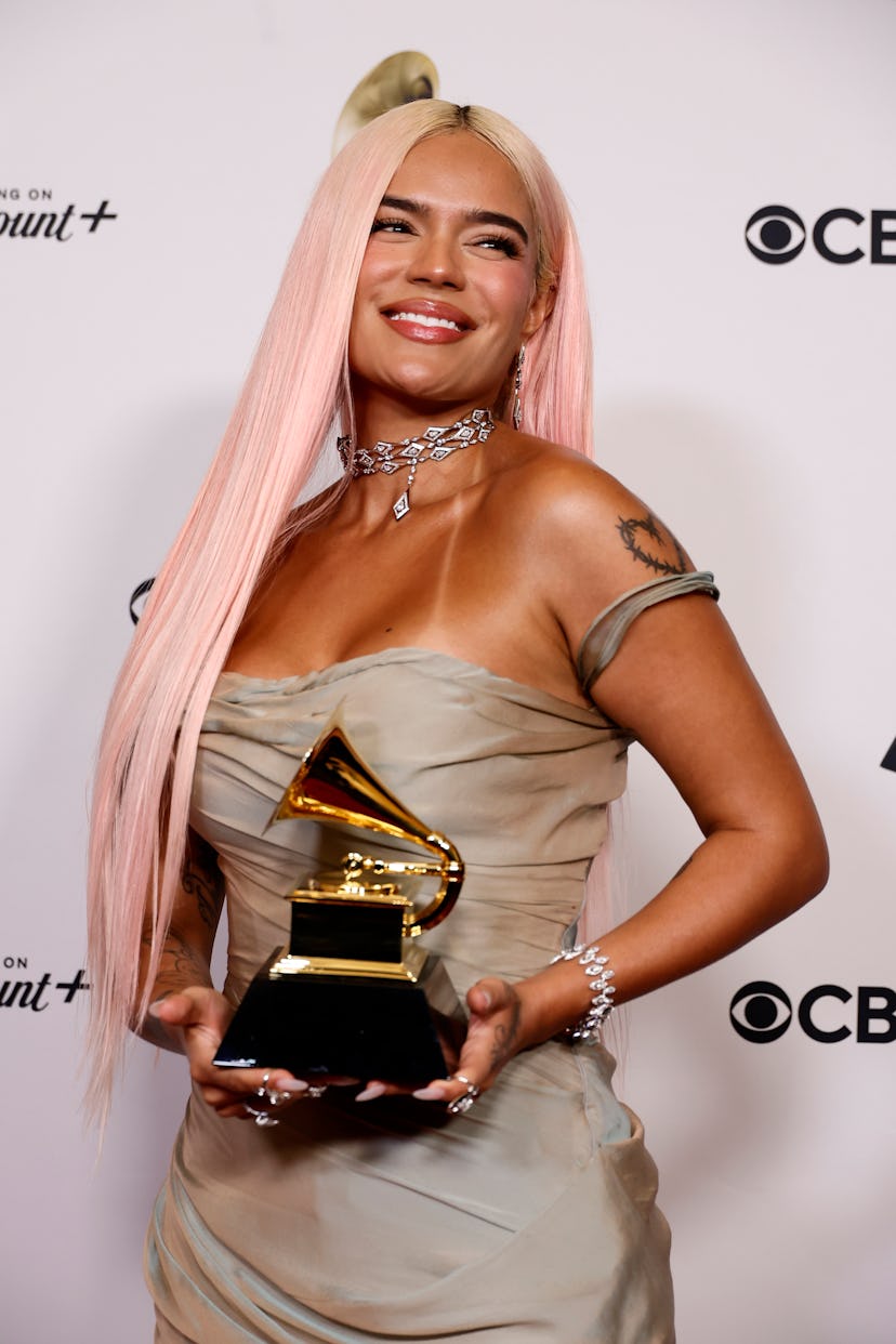 Karol G. attends the 66th GRAMMY Awards with sleek and straight peach fuzz-colored hair.