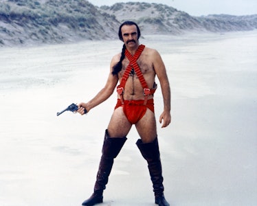 Sean Connery, British actor, holding a handgun while wearing thigh-high boots and red costume, with ...
