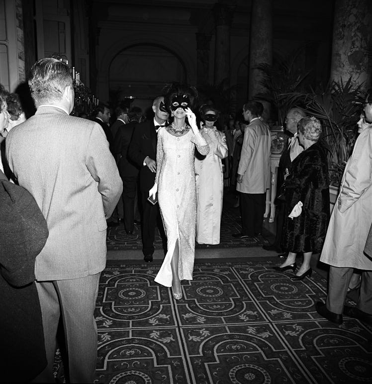 A masked Gloria Guiness arriving at Truman Capote's Black and White Ball in the Grand Ballroom at th...