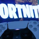 PlayStation DualSense controller and Fortnite on PlayStation Store displayed on a tv screen are seen...