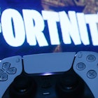 PlayStation DualSense controller and Fortnite on PlayStation Store displayed on a tv screen are seen...