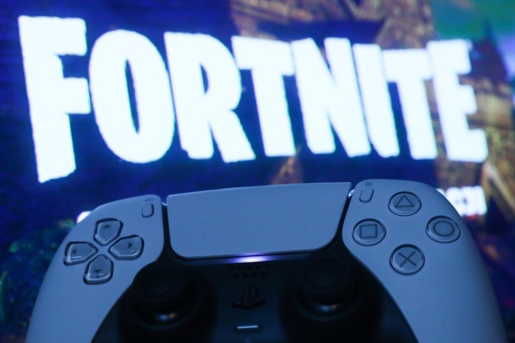 PlayStation DualSense controller and Fortnite on PlayStation Store displayed on a tv screen are seen...