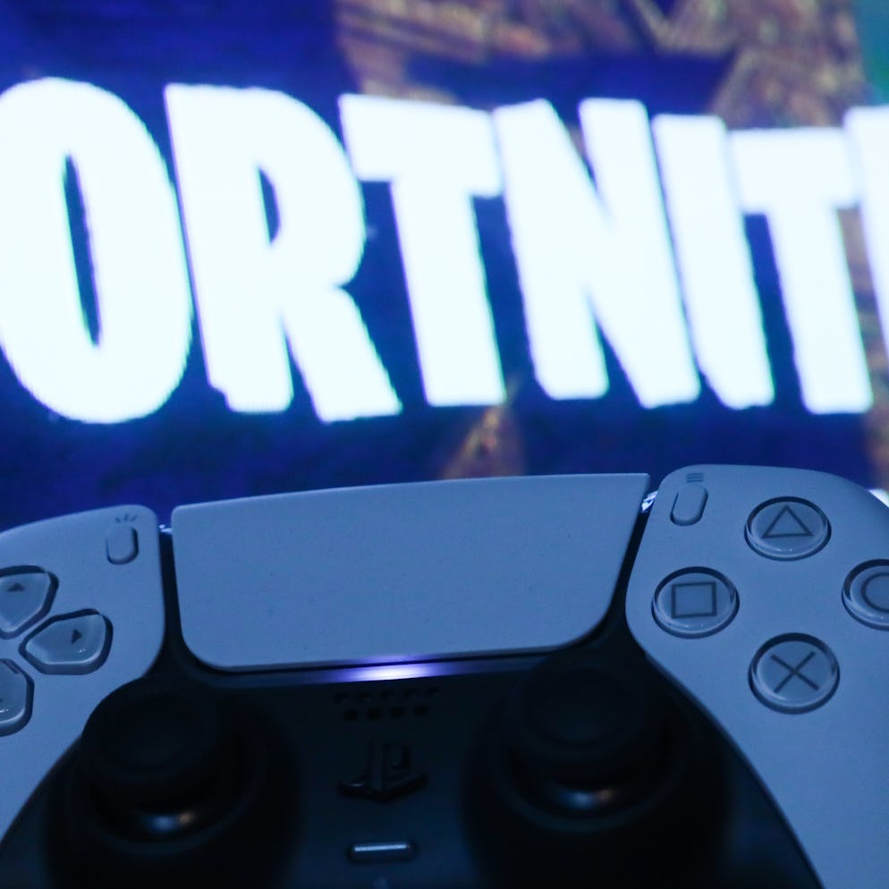 PlayStation DualSense controller and Fortnite on PlayStation Store displayed on a tv screen are seen...