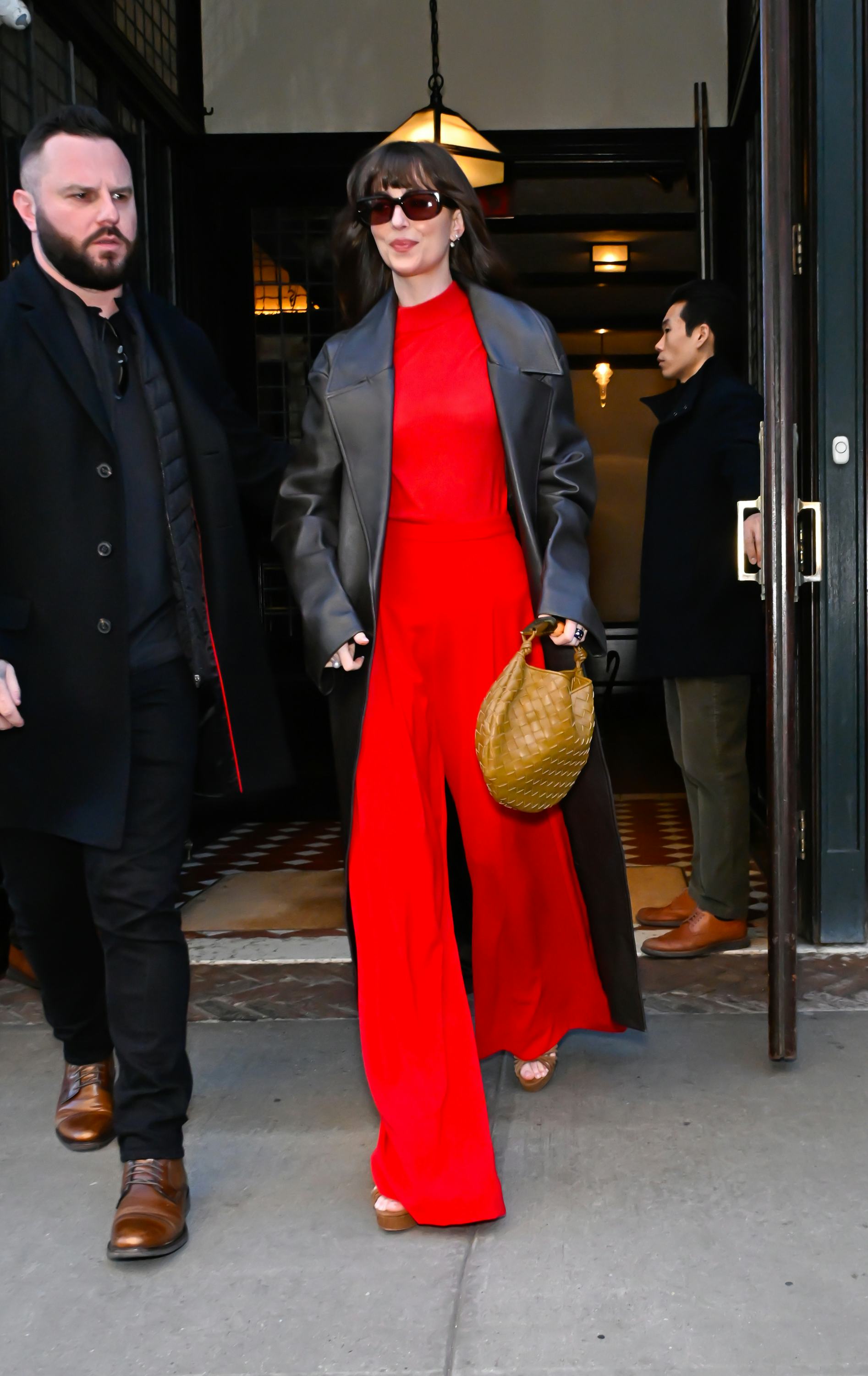 Dakota Johnson wears a red jumpsuit and leather trench in soho on February 07, 2024 in New York City&hellip;