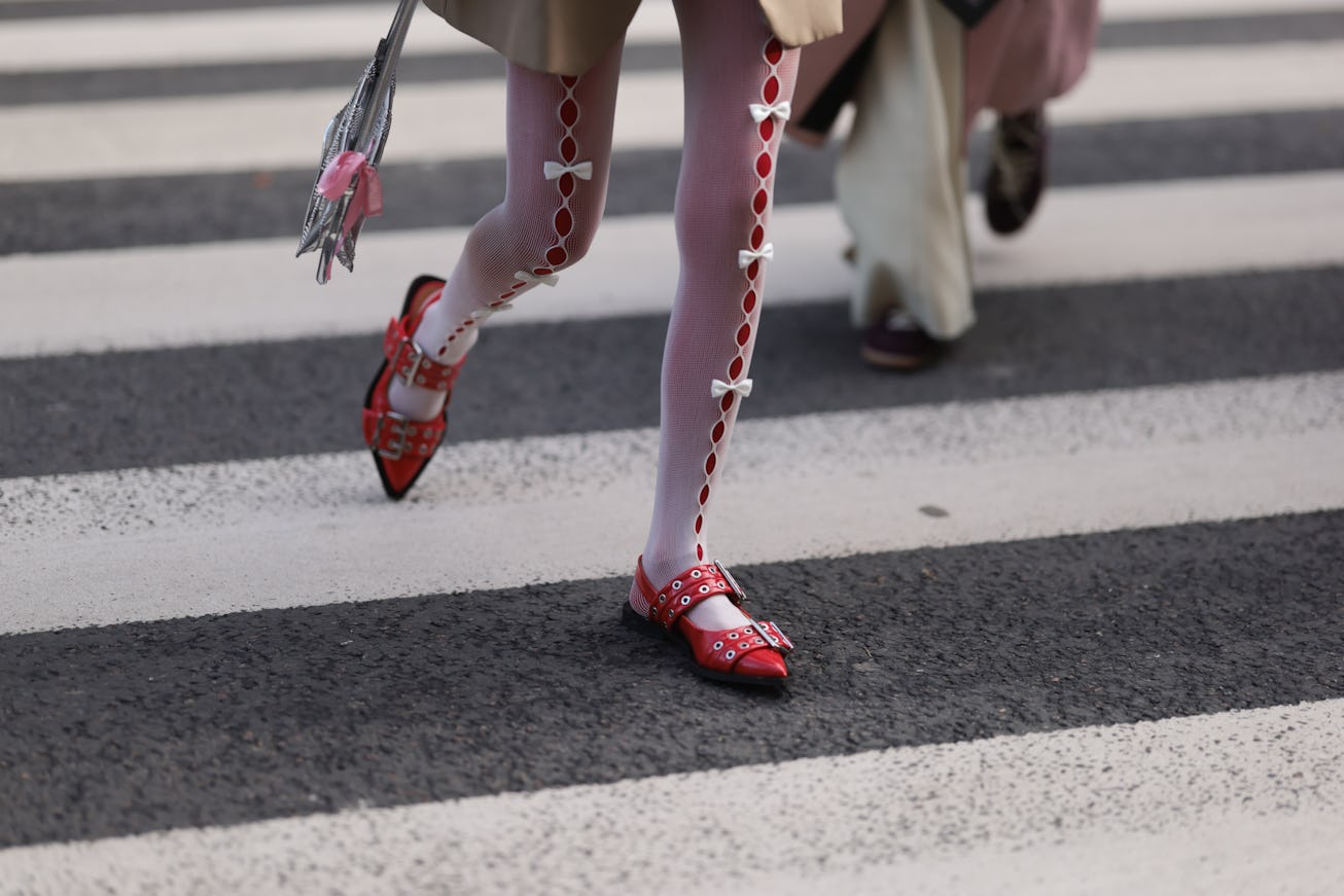 PARIS, FRANCE - JANUARY 24: A Guest is seen wearing white tights with ribbons, silver handbag and re...