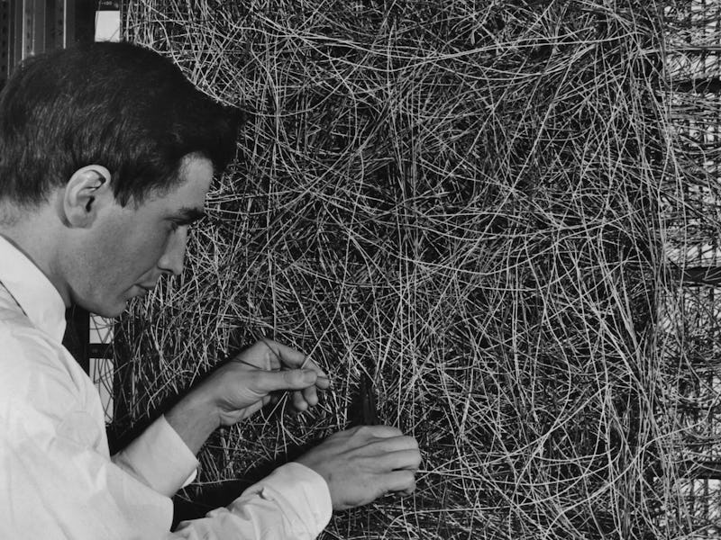 A man adjusting the random wiring network between the light sensors and association unit of scientis...