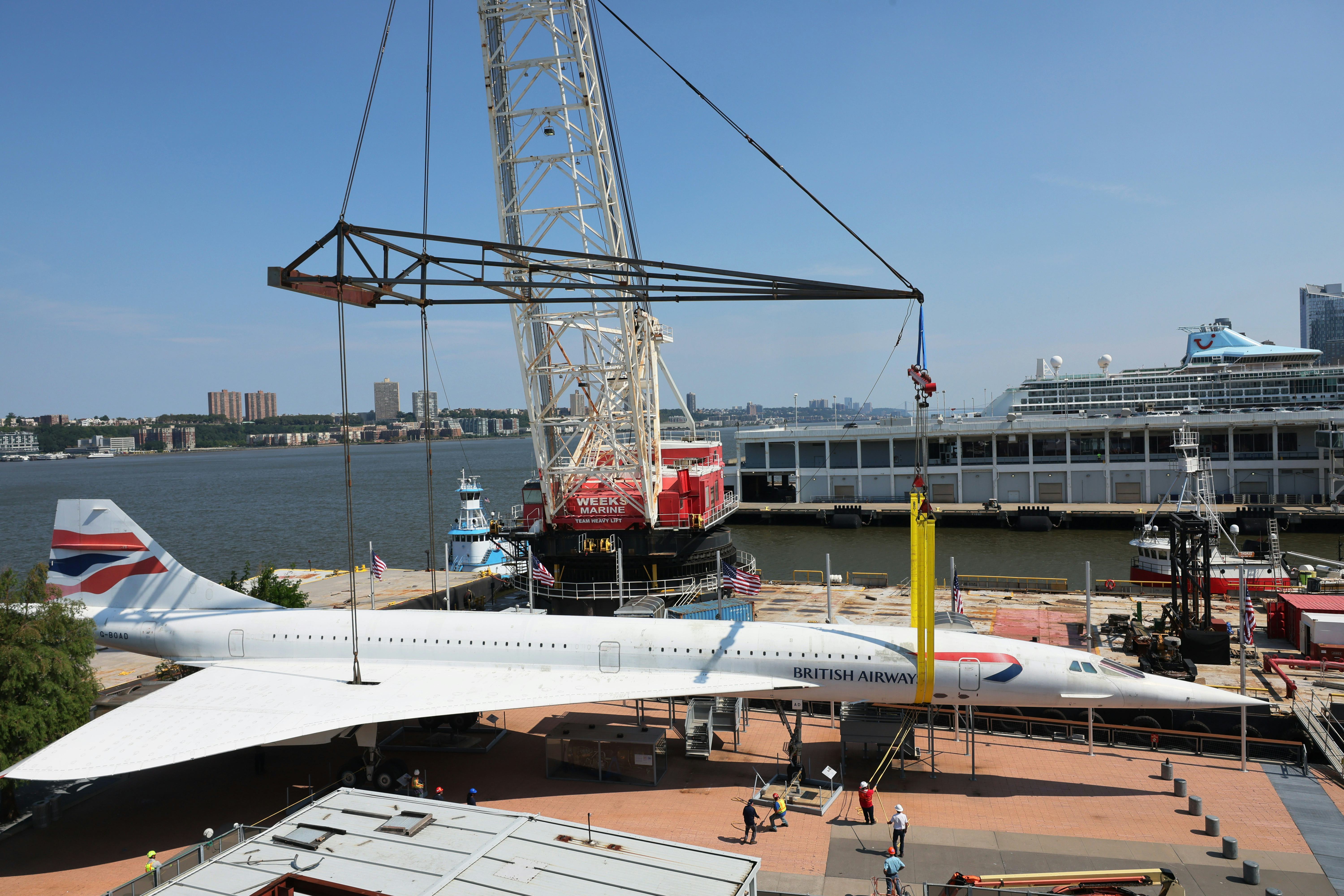 NEW YORK, NEW YORK - AUGUST 09: Workers place the British Airways Concorde on a harness at the Intre...