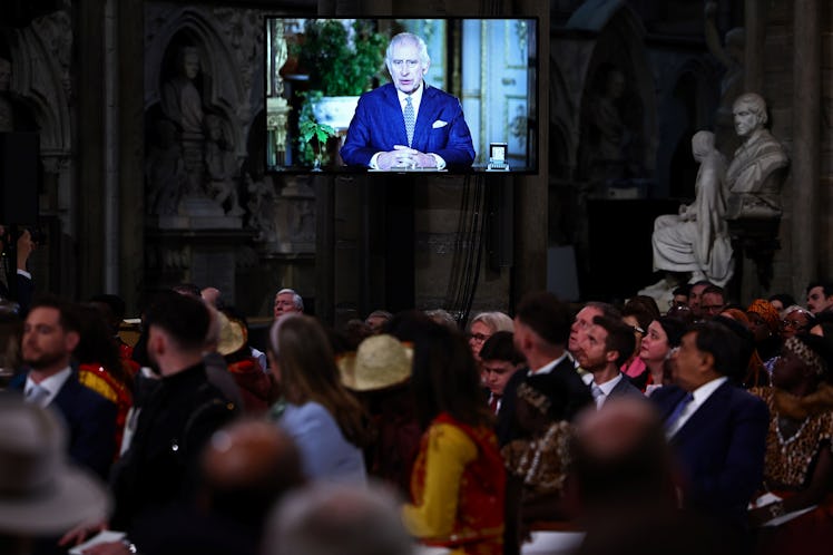 Guests watch a video of Britain's King Charles III delivering a message during the 2024 Commonwealth...