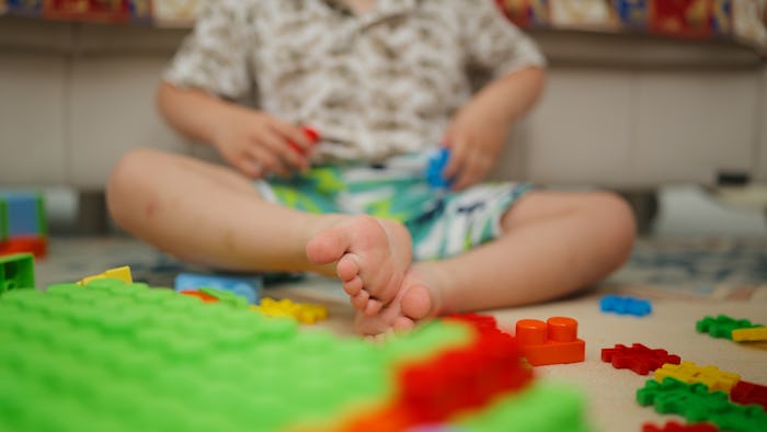A small boy is playing in the living room at home.