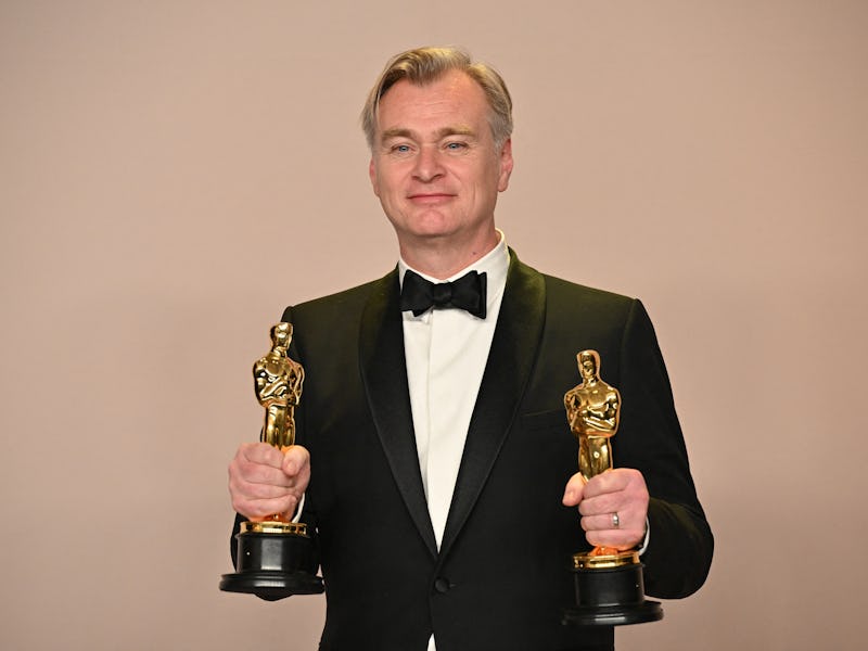 British director Christopher Nolan poses in the press room with the Oscars for Best Director and Bes...