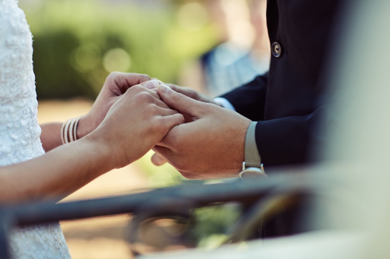 Cropped shot of a couple holding hands on their wedding day