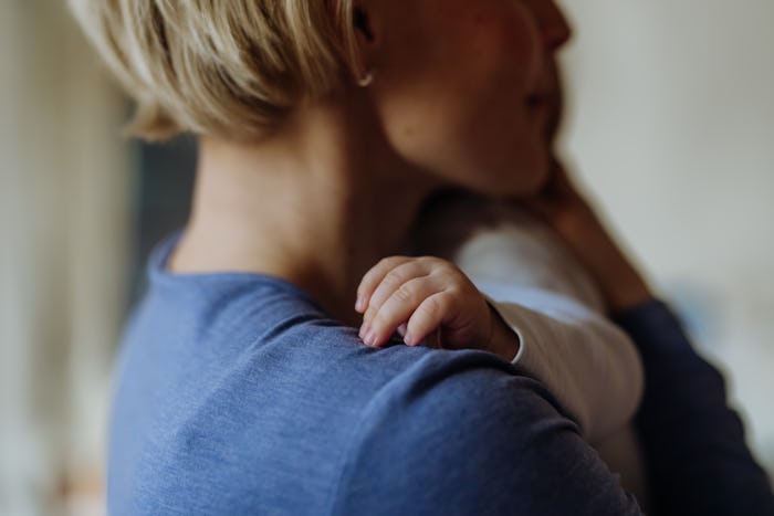 Close up of mother holding and cuddling her baby. Concept of mothers love.