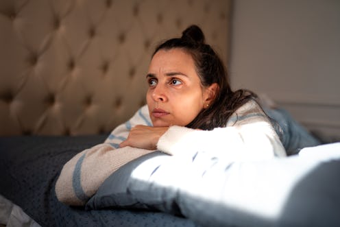 Worried woman at home checking smart phone