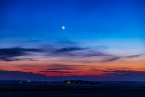 The two-day-old waxing crescent moon with Earthshine, above Mercury at right, then 4 days past its g...