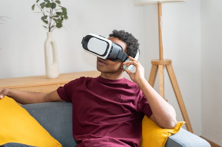 Male adjusting his VR headset at home on the couch