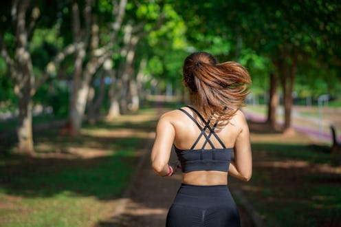 Young fitness sports women runner running in the park. Happy athletic woman listening music on earph...