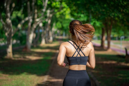 Young fitness sports women runner running in the park. Happy athletic woman listening music on earph...