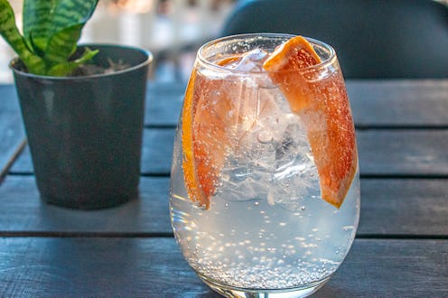 Glass of lemonade with slices of grapefruit / orange and ice.