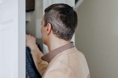 Close-up of mid adult man reaching into closet