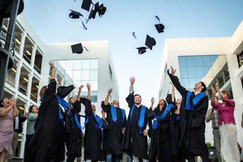 Young graduates throwing their mortarboard in the air while celebrating on graduation