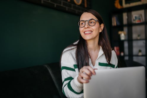 Young smiling woman enjoying her working day in a coffee shop