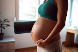 Pregnant woman getting ready to exercise at home, in a story about skin tags during pregnancy.