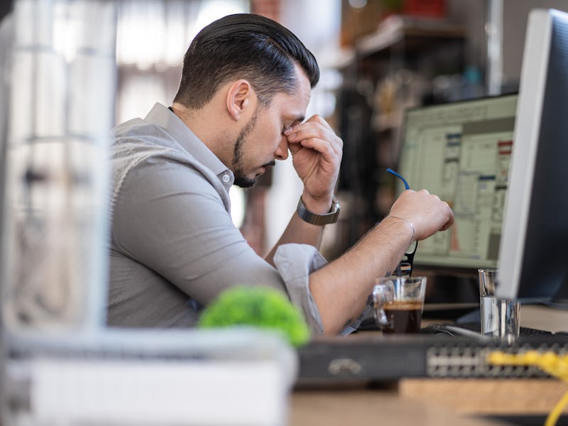 Shot of a stressed out man working in a demanding career
