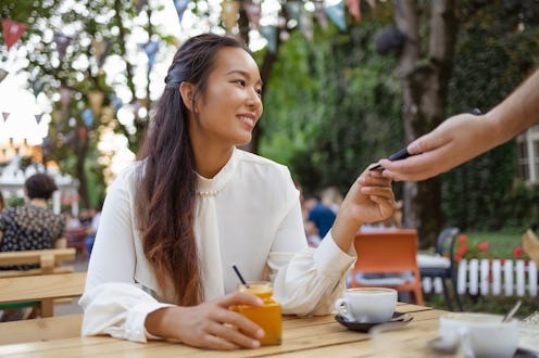 Young Happy Asian Woman Pay Waiter Wireless Bank Payment Terminal Process Acquire Credit Card Sit at...