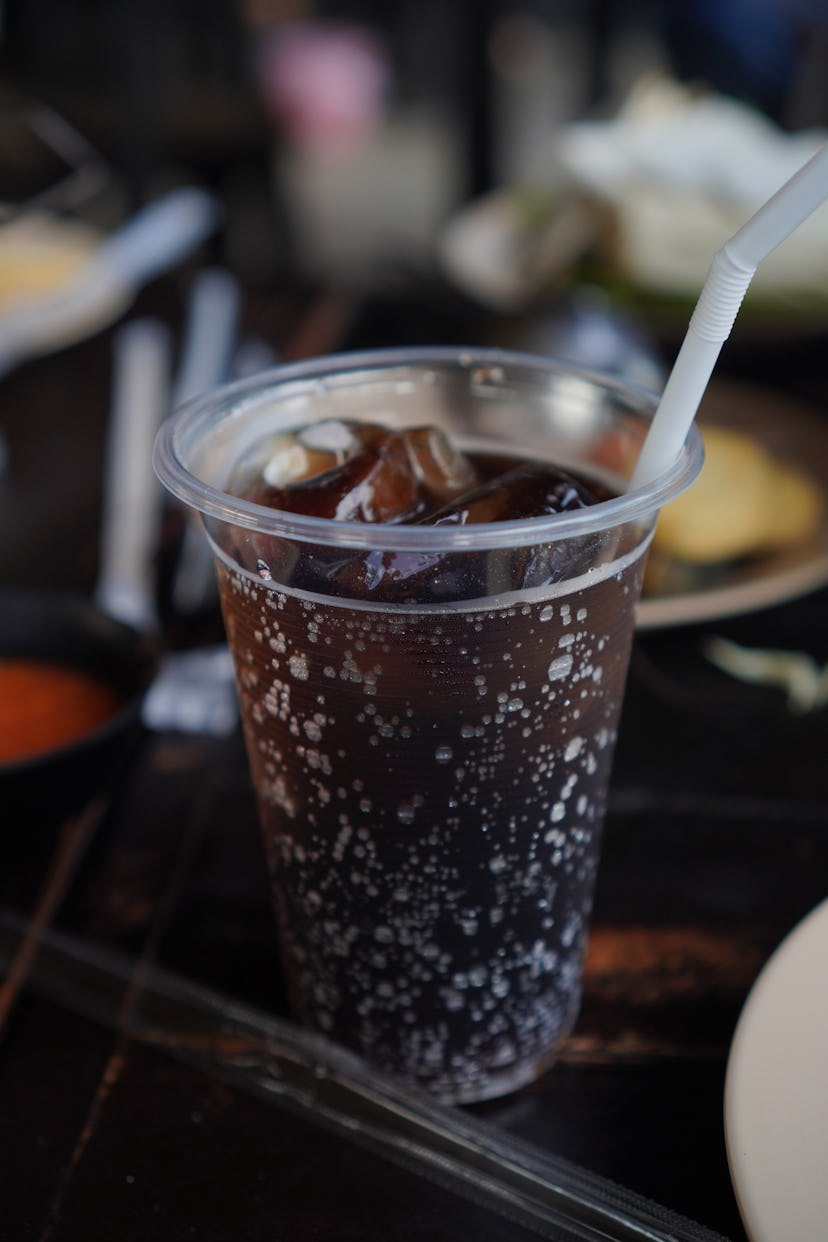 Drink Beverage, iced Cola in plastic cup on wooden table