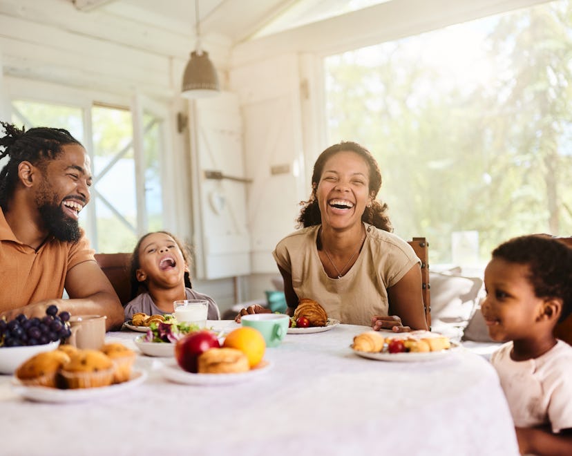 Cheerful African American family having fun during a meal in dining room.