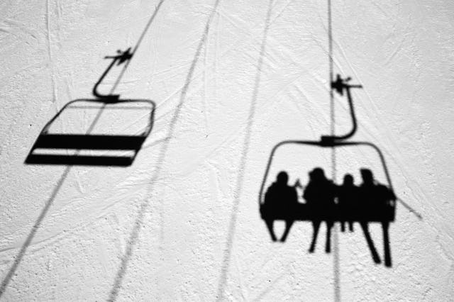 A family shadow of a chair lift on a mountain in Vermont