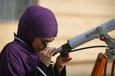 A student at Baghdad University uses a telescope to observe a partial solar eclipse in Iraq's capita...