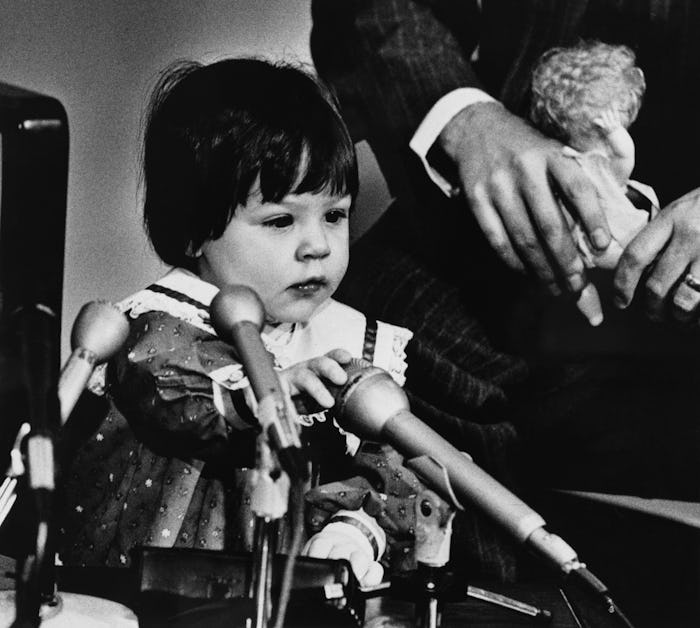 Elizabeth Jordan Carr plays with the microphones during a news conference. She and her parents, Jud...