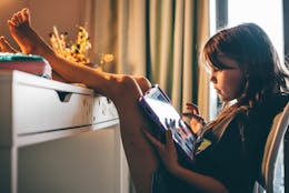 Girls using digital tablet in children's room at home.