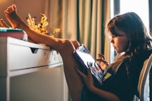 Girls using digital tablet in children's room at home.