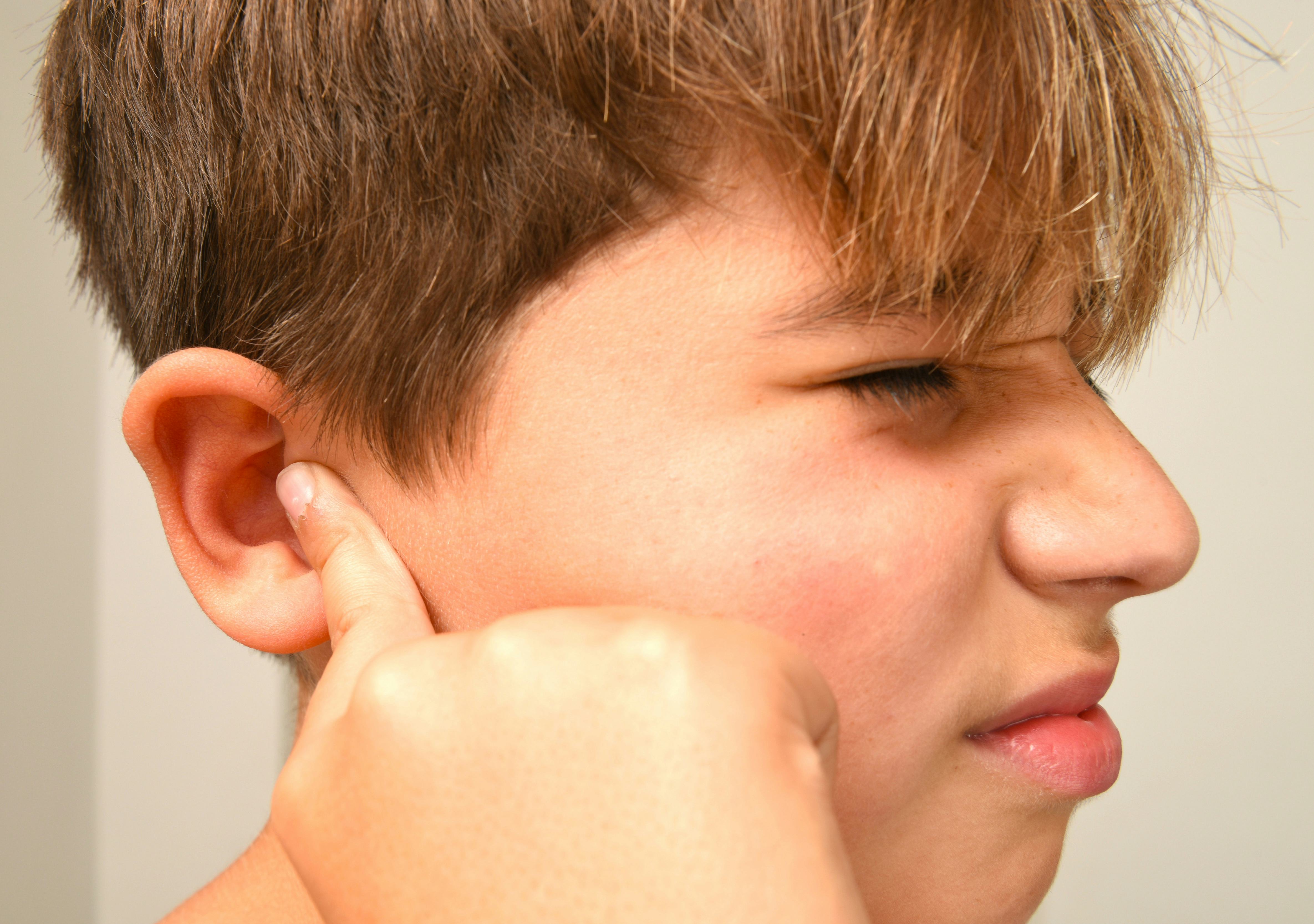 Boy with fingers in ear, too loud